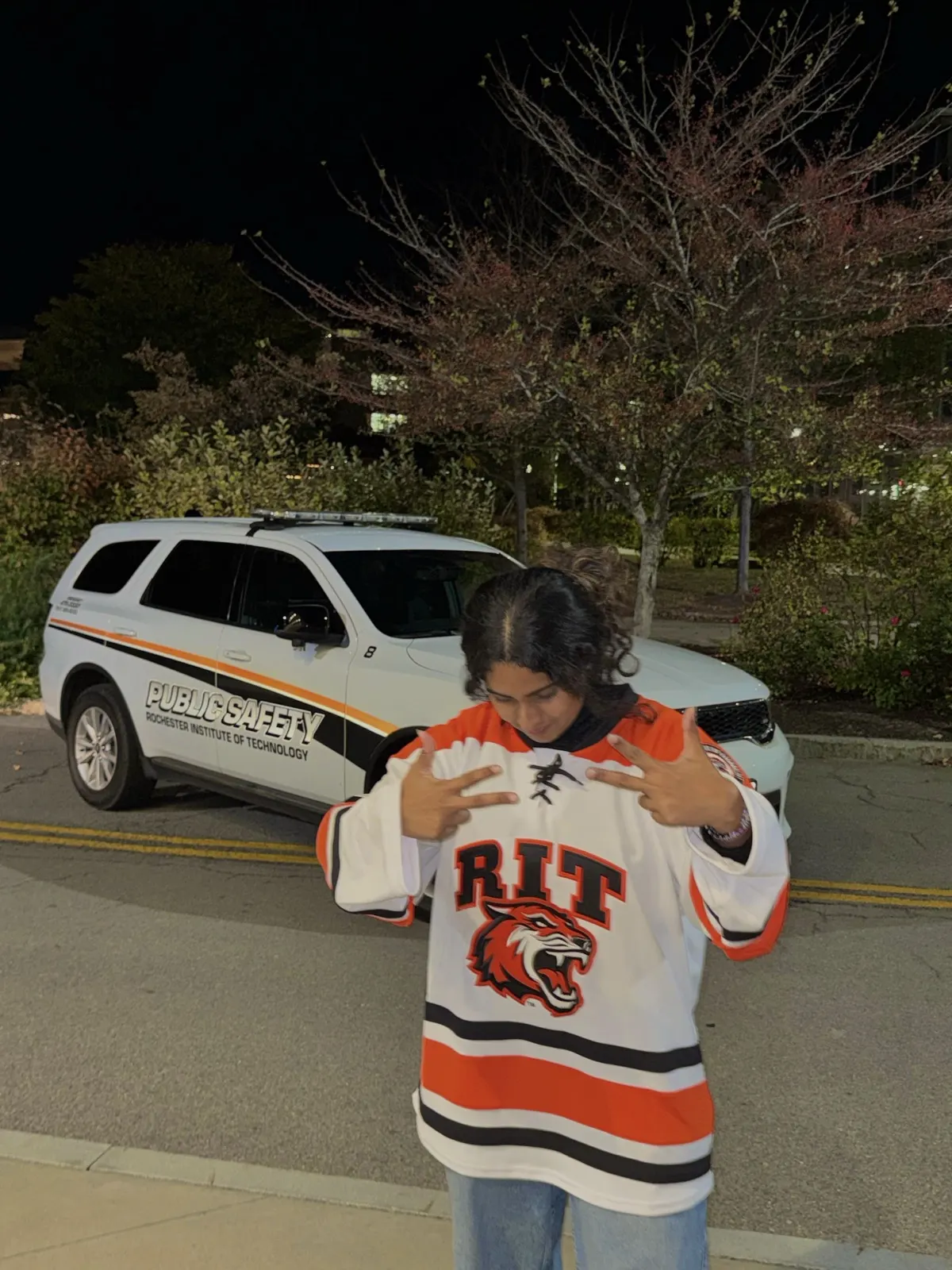 Anusha Seshadri in an RIT hockey jersey at night